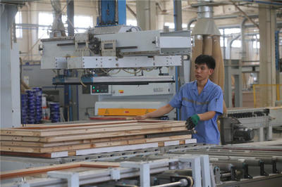 蘭考縣一家家居企業的生產車間里,工作人員在處理家具板材.jpg
